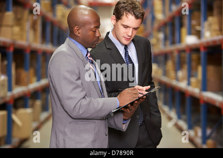 Due imprenditori aventi la discussione in magazzino Foto Stock