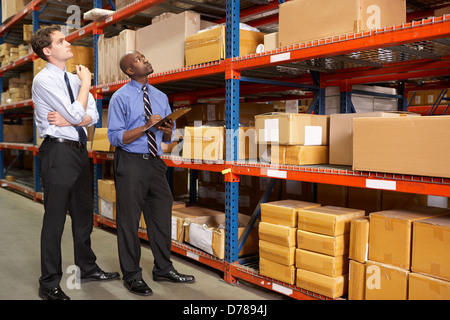 Due imprenditori con appunti in magazzino Foto Stock