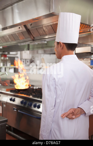 Lo Chef con le dita incrociate come una pentola prende fuoco Foto Stock