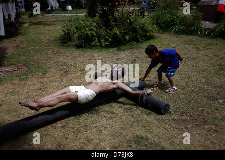 Un ragazzo tocca e immagine del Buon Ladrone durante la Semana Santa in La Antigua Guatemala, Marzo 27, 2013. Foto Stock