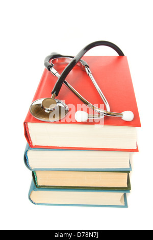 Lo stetoscopio e pila di libri vicino fino isolato su sfondo bianco. Medico di informazione e di educazione del concetto. Foto Stock