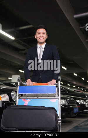 Traveler spingendo il carrello in airport parking lot Foto Stock