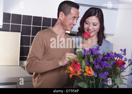 Coppia matura con bouquet di fiori, uomo tenendo una rosa Foto Stock