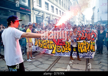 Milano, Italia - 1 Maggio 2013: un ragazzo contiene un gas lacrimogeno sparato durante le celebrazioni del giorno di maggio a Milano dove migliaia di persone si riuniscono per celebrare il giorno di maggio e per protestare contro le misure di austerità. Credito: Piero Cruciatti / Alamy Live News Foto Stock