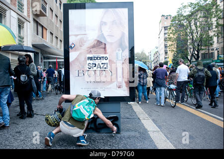 Milano, Italia - 1 Maggio 2013: un ragazzo tag di un banner con spray durante le celebrazioni del giorno di maggio a Milano dove migliaia di persone si riuniscono per celebrare il giorno di maggio e per protestare contro le misure di austerità. Credito: Piero Cruciatti / Alamy Live News Foto Stock