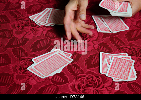 Donna che tratta un pacchetto di carte da gioco. Foto Stock