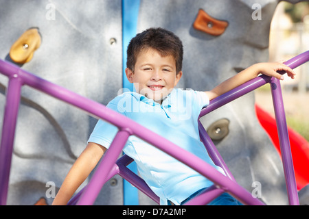 Ragazzo sul telaio di arrampicata in posizione di parcheggio Foto Stock