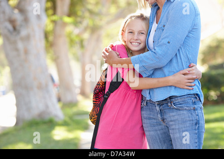 Madre e figlia andare a scuola a piedi sulla strada suburbana Foto Stock