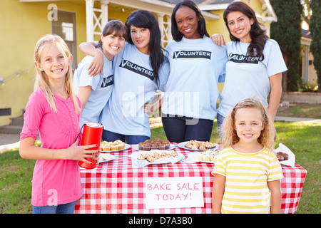 Le donne e i bambini in esecuzione la carità cuocere la vendita Foto Stock