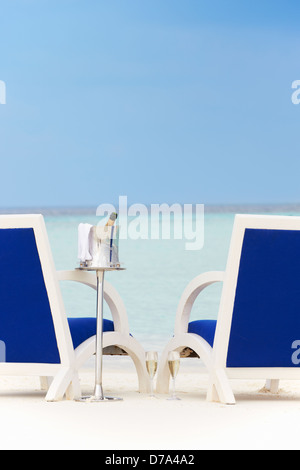 Bottiglia di Champagne tra sedie sulla bellissima spiaggia Foto Stock