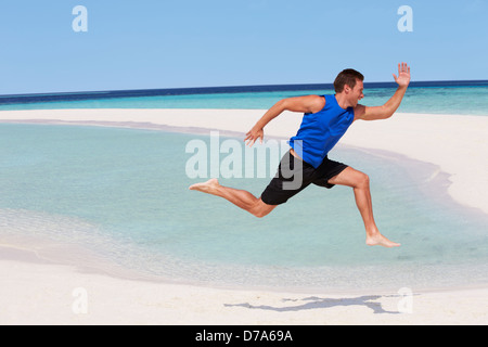 L'uomo esercita sulla bellissima spiaggia Foto Stock