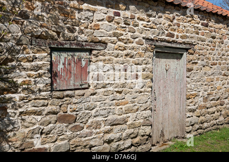 Tapparella e porta in legno su fienile in pietra nell'edificio agricolo North Yorkshire Inghilterra Regno Unito Gran Bretagna Foto Stock