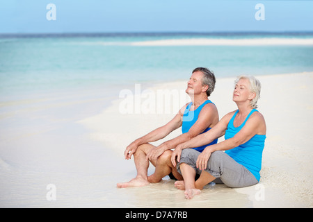 Coppia senior in abbigliamento sportivo relax sulla splendida spiaggia Foto Stock