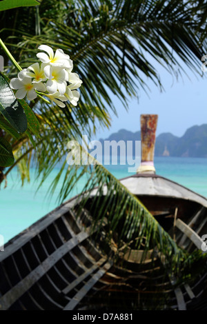 Bella Tailandia Isole colpo di long-tailed barca che si affacciano sull'oceano con monoï di fiori e foglie di palma sul forescene Foto Stock