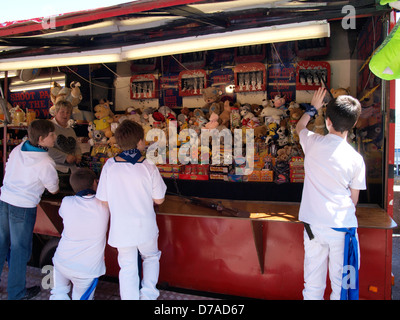 I ragazzi ad una galleria di tiro, fiera di stallo, Regno Unito 2013 Foto Stock