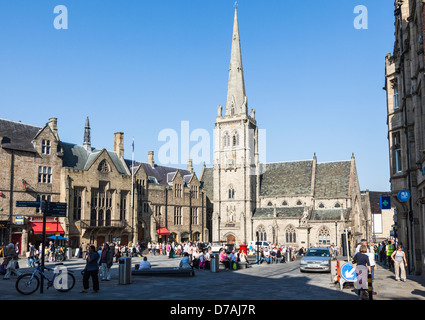 Durham city centre marketplace, con St Nicholas' la chiesa con la sua alta guglia in background sotto un cielo blu in estate Foto Stock