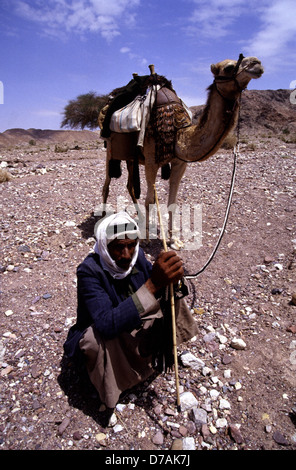 Il nomade beduino membro della tribù Zawaideh, nativo per i deserti della Giordania Meridionale e western Arabia Saudita con il suo cammello nel Wadi Rum desert conosciuta anche come la Valle della Luna in Giordania Meridionale Foto Stock