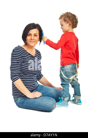 Il Toddler boy pettini a sua madre capelli isolati su sfondo bianco Foto Stock