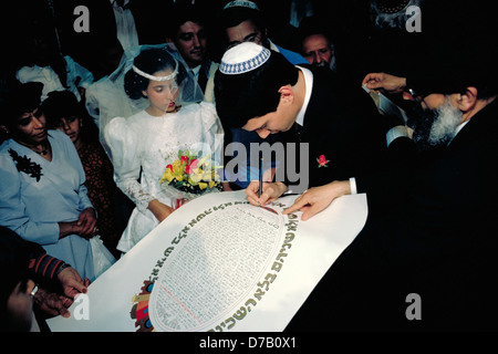 Sposo segni il suo Ketubah a un matrimonio Foto Stock