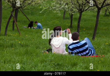 Passeggiata romantica sulla collina di Petrin, coppia di Praga nella Repubblica Ceca seduto in un parco erboso Foto Stock