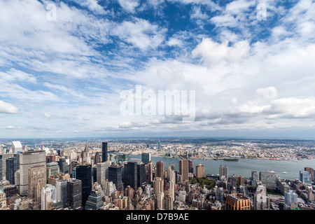 Skyline di Manhattan e nuvole bianche su un cielo blu - vista verso est a partire dall'Empire State building observation deck Foto Stock
