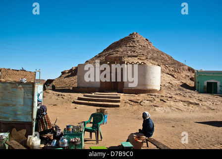 Strada di Wadi Halfa, bollitore per tè e caffè lady e il suo cliente in fg, Mazar Midhat Ufficio viaggi in bg, Sudan settentrionale Foto Stock