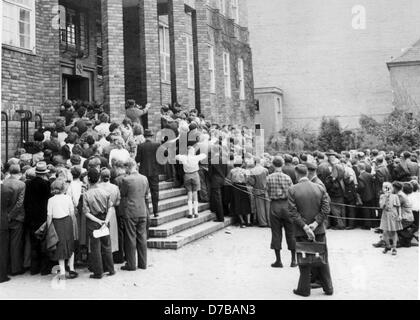 I rifugiati provenienti dalla zona sovietica, che hanno l'emergenza procedure di ammissione alle loro spalle, ora sono in attesa del loro volo per la Germania occidentale a aeroporto di Tempelhof di Berlino. Immagine dal gennaio 1953. Foto Stock