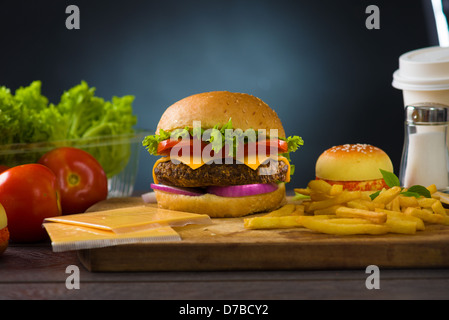 Formaggio hamburger con abbondanza di fast foods ingredienti sullo sfondo Foto Stock