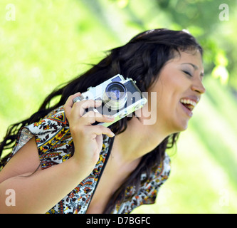 Donna sorridente tenendo la fotocamera vintage Foto Stock