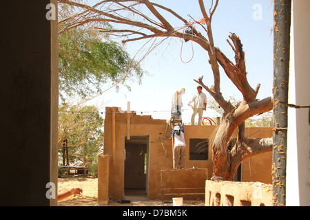 Edificio ecologico nel Kibbutz Neot Semadar utilizzando locale di fango nel deserto per applicare il cerotto alla parete, nel Negev, a sud di Israele Foto Stock