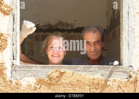 Edificio ecologico nel Kibbutz Neot Semadar utilizzando locale di fango nel deserto per applicare il cerotto alla parete, nel Negev, a sud di Israele Foto Stock