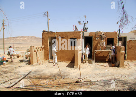 Edificio ecologico nel Kibbutz Neot Semadar utilizzando locale di fango nel deserto per applicare il cerotto alla parete, nel Negev, a sud di Israele Foto Stock