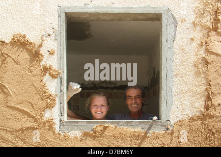 Edificio ecologico nel Kibbutz Neot Semadar utilizzando locale di fango nel deserto per applicare il cerotto alla parete, nel Negev, a sud di Israele Foto Stock