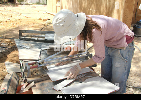 Lavoratore di sesso femminile che impegnato nella costruzione ecologica nel Kibbutz Neot Semadar nel Negev, a sud di Israele Foto Stock