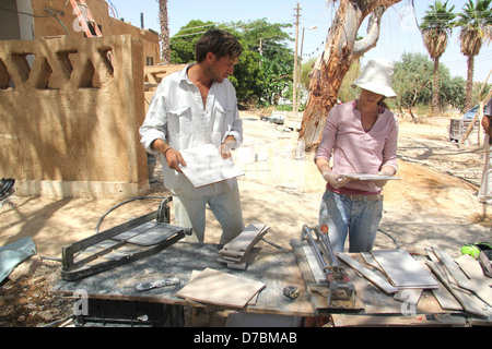 Lavoratori di sesso maschile e di sesso femminile impegnata nella costruzione ecologica nel Kibbutz Neot Semadar nel Negev, a sud di Israele Foto Stock