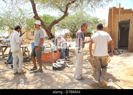 Kibbutz membri impegnati nella costruzione ecologica nel Kibbutz Neot Semadar nel Negev, a sud di Israele Foto Stock