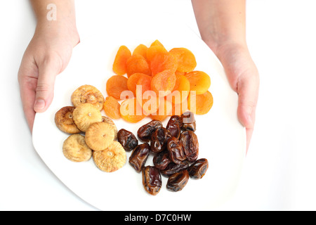 Piastra con frutta secca in mani umane Foto Stock