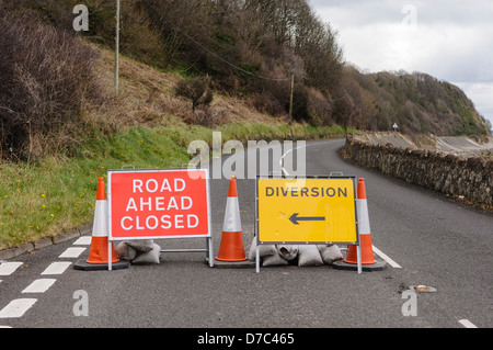 Strada chiusa segni su una strada costiera a causa di caduta massi. Foto Stock