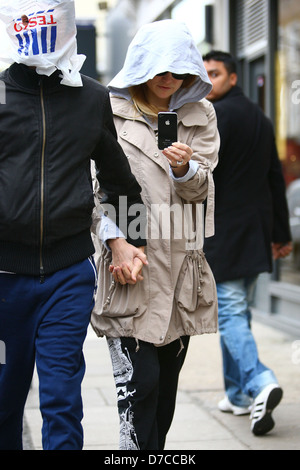 Matt Bellamy e Kate Hudson a piedi nella zona nord di Londra. Bellamy coperto la sua testa con un sacchetto di Tesco, guardando fuori attraverso un singolo Foto Stock