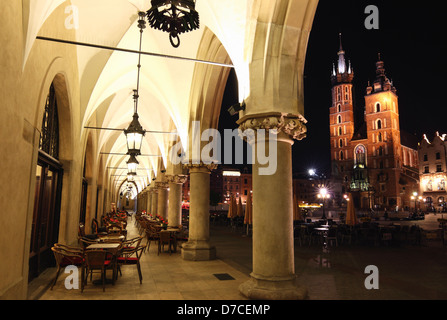 La Piazza del Mercato di Cracovia di notte basilica dell'assunzione di nostra Signora ( Santa Maria ) visto dal mercato arcade . Polonia Foto Stock