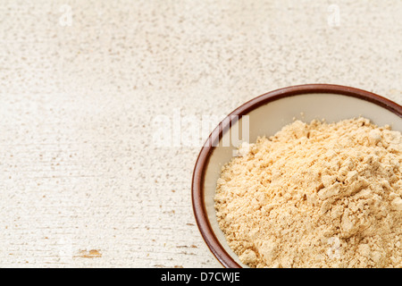 Radice di maca in polvere (nutrition supplemento - super da Andies) in una piccola ciotola di ceramica su un fienile rustico legno Foto Stock