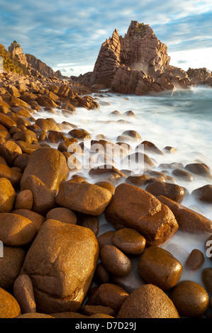 La spiaggia rocciosa al di pinnacoli di Cape Woolamai sul circuito di Phillip Island al tramonto Foto Stock