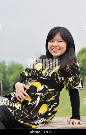 Una bella incinta donna asiatica per esterno Foto Stock