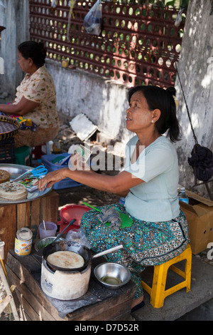 Donna al fast food La cucina di stallo frittelle in Bogyoke (ex Scott) Mercato di Yangon, Myanmar Foto Stock
