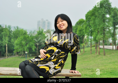 Una bella incinta donna asiatica per esterno Foto Stock