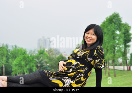 Una bella incinta donna asiatica per esterno Foto Stock