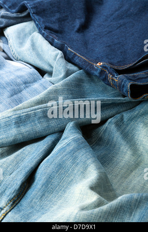 Varie paia di jeans pantaloni sparsi nel caos. Foto Stock