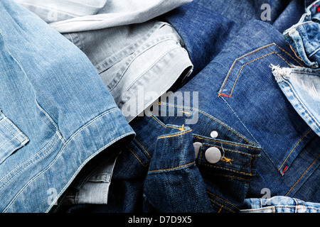 Varie paia di jeans pantaloni sparsi nel caos. Foto Stock