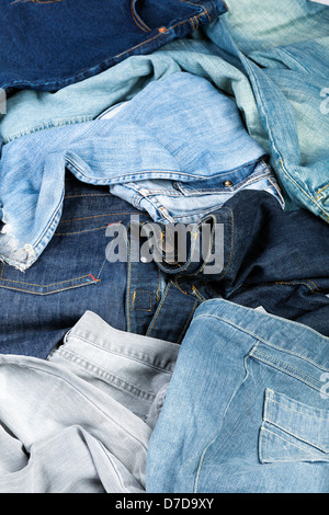 Varie paia di jeans pantaloni sparsi nel caos. Foto Stock