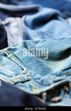 Varie paia di jeans pantaloni sparsi nel caos. Foto Stock